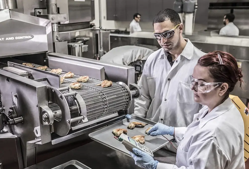 Food technicians inspecting items on a production line.