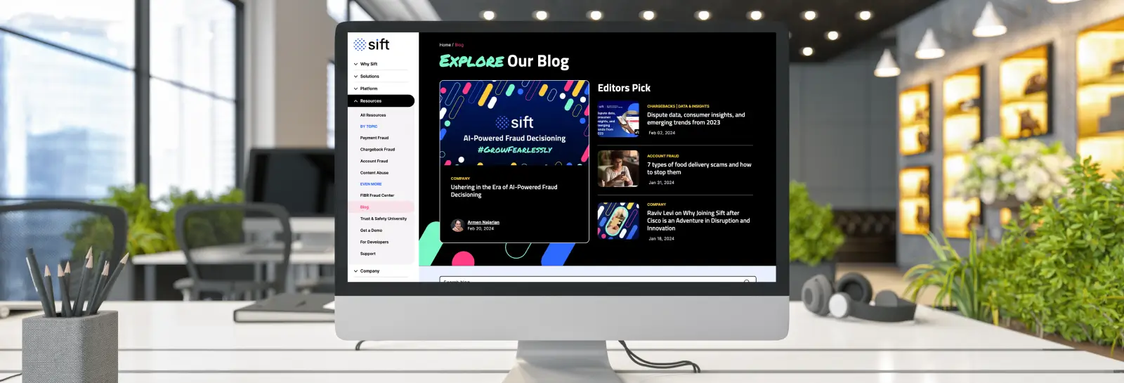 iMac on an office desk displaying the Sift blog page with AI-powered fraud decisioning articles and editor's picks.