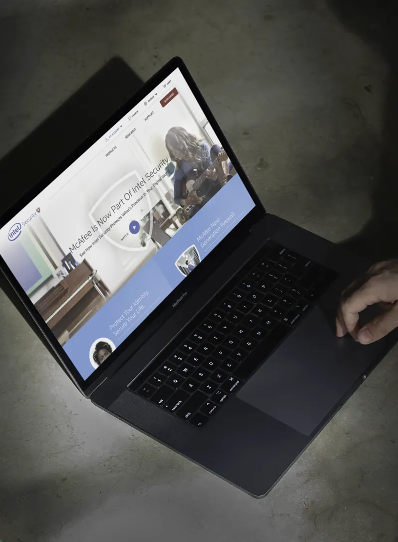 Laptop displaying the Intel Security and McAfee cybersecurity website interface.